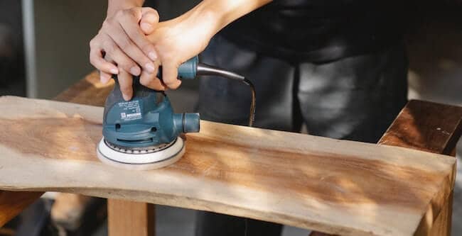 electric sander used to on wooden surface