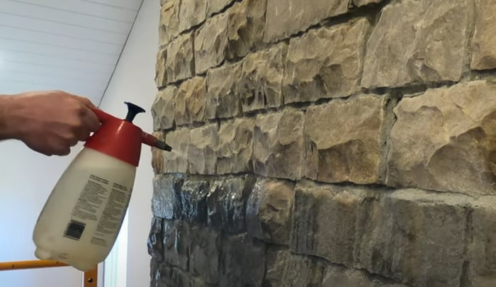 home sprayer used to remove mildew from stone fireplace wall 