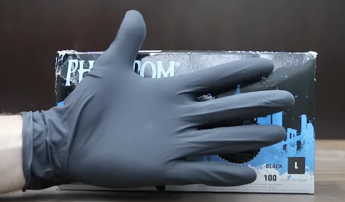Man wearing rubber gloves to protect skin surface from chemical burns