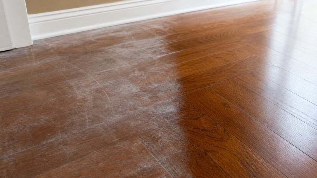 Cloudy white film on wood floors next to a cleaned section of hardwood
