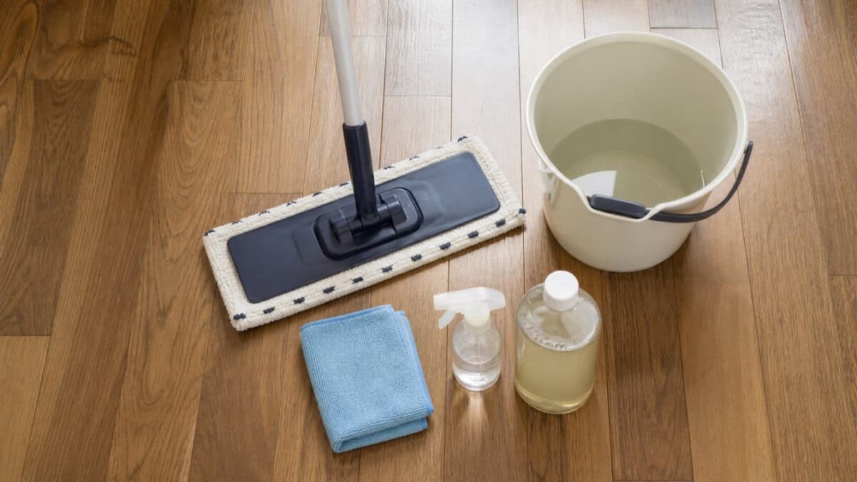 Microfiber mop, cloth, bucket, and gentle cleaner for removing white film on wood floors